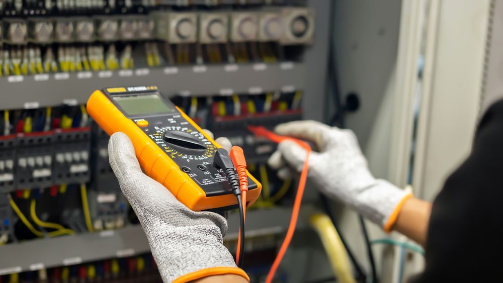 Gloved Hands Use a Multimeter on Electrical Control Panel Wiring — Cairns Excel Electrics In Redlynch, QLD