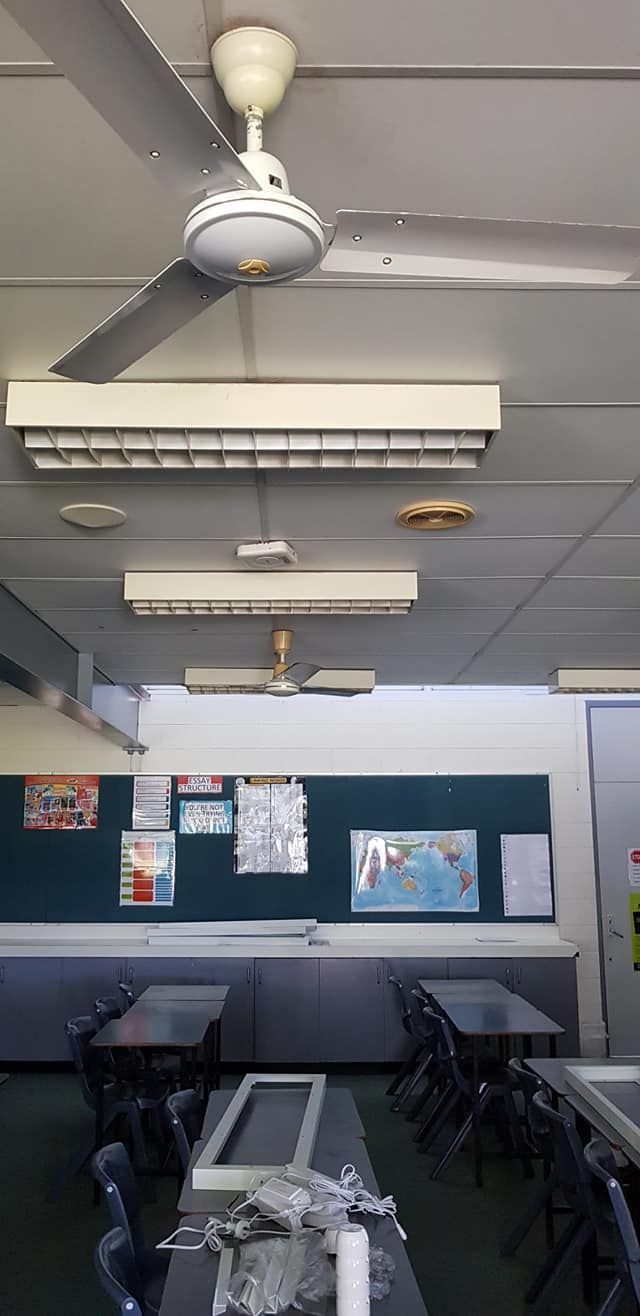 A Classroom With Tables And Chairs And A Ceiling Fan — Cairns Excel Electrics In Bungalow, QLD