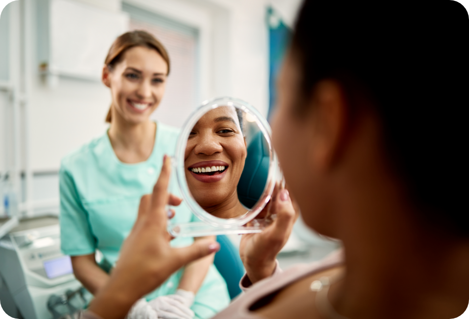 Asset class - Elective Medical/Dental - A woman is looking at her teeth in a mirror at the dentist.