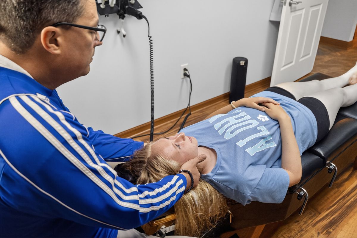 Chiropractor adjusting a patient lying on a treatment table in a clinic