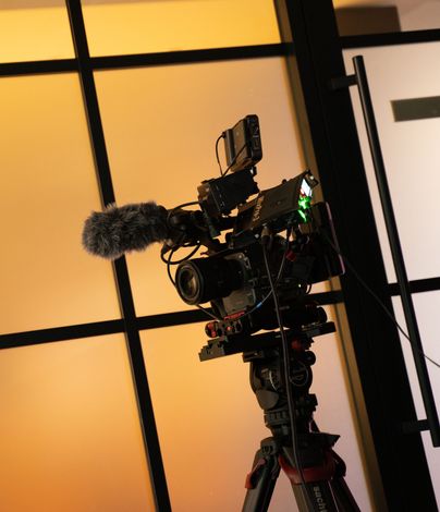 A camera on a tripod with a microphone attached to it