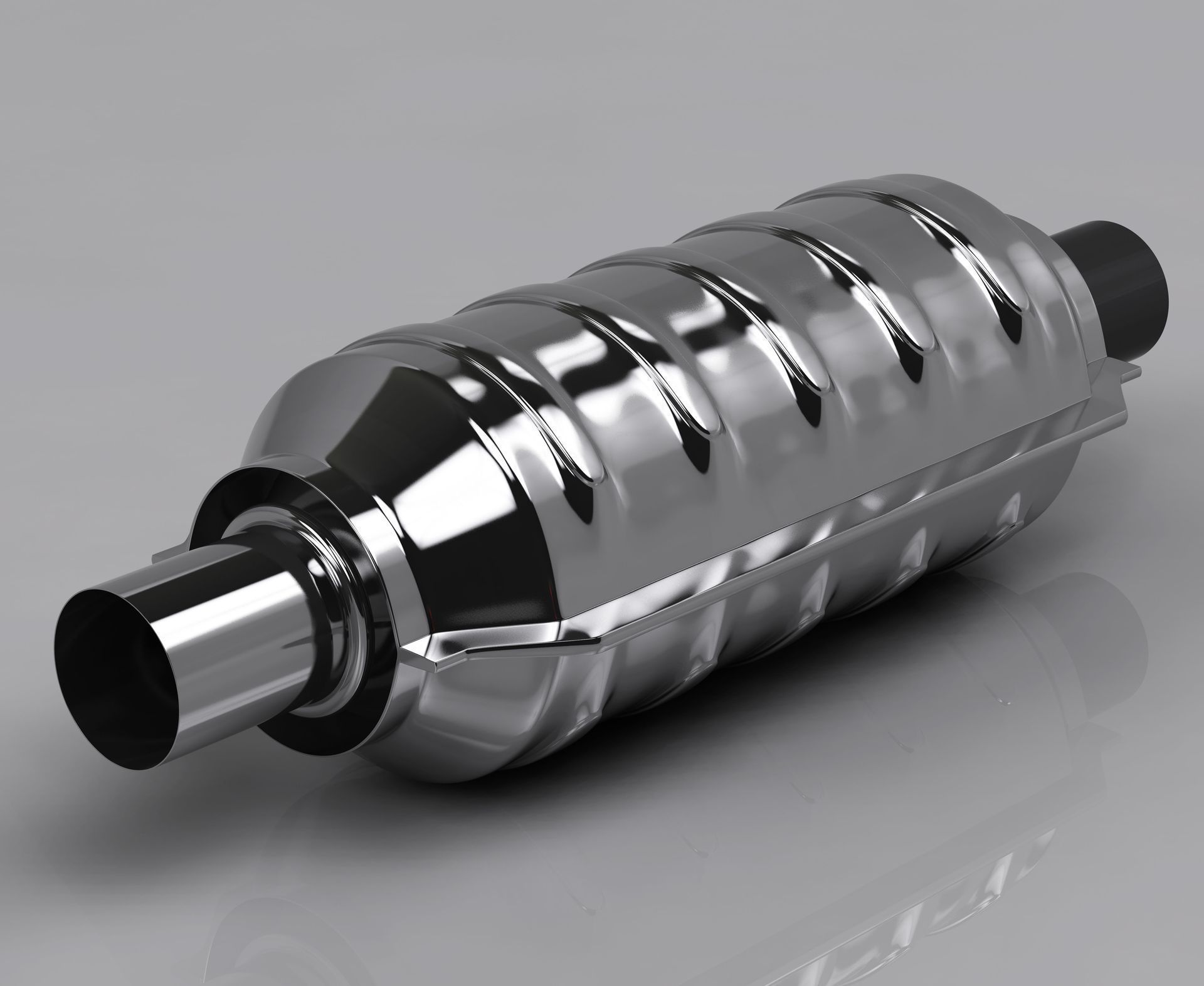 Shiny chrome car exhaust muffler with black inlet and outlet on a gray background