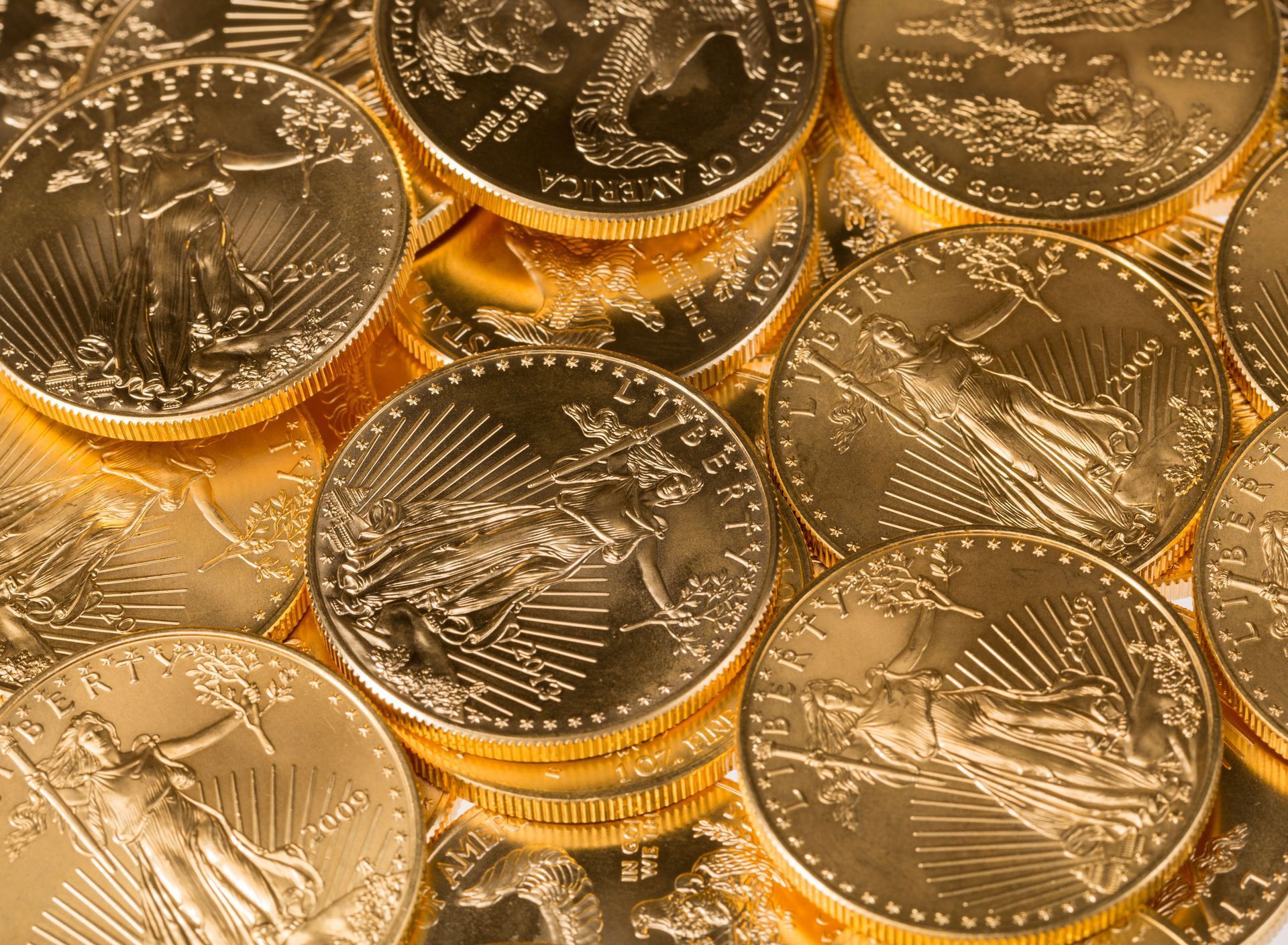 Close-up of stacked gold-colored coins with intricate designs and textured edges