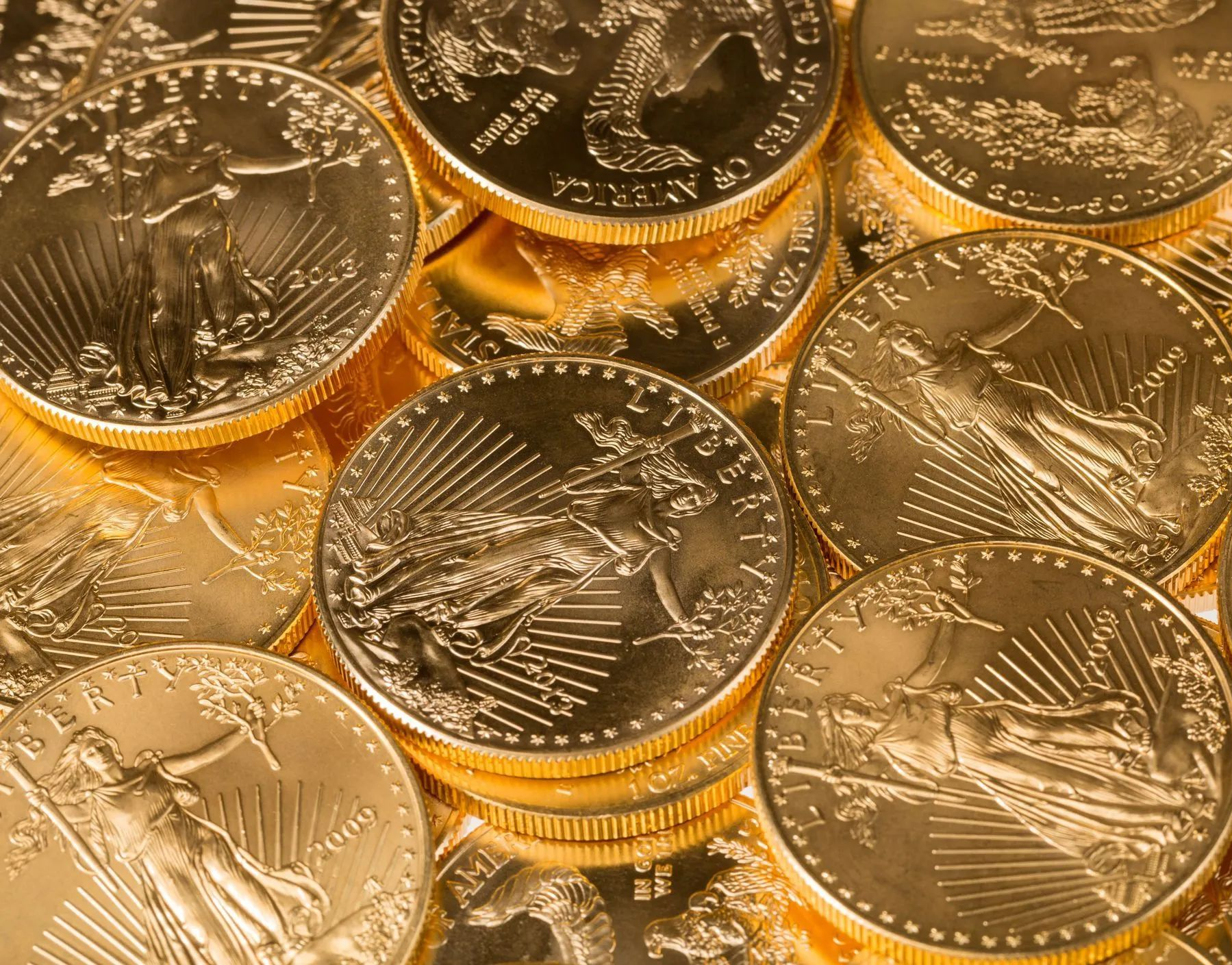 Close-up of stacked gold coins with an American eagle design on a warm background