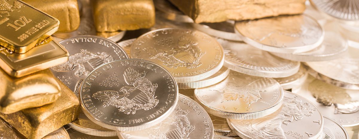 Gold bars and silver coins piled together, reflecting warm light