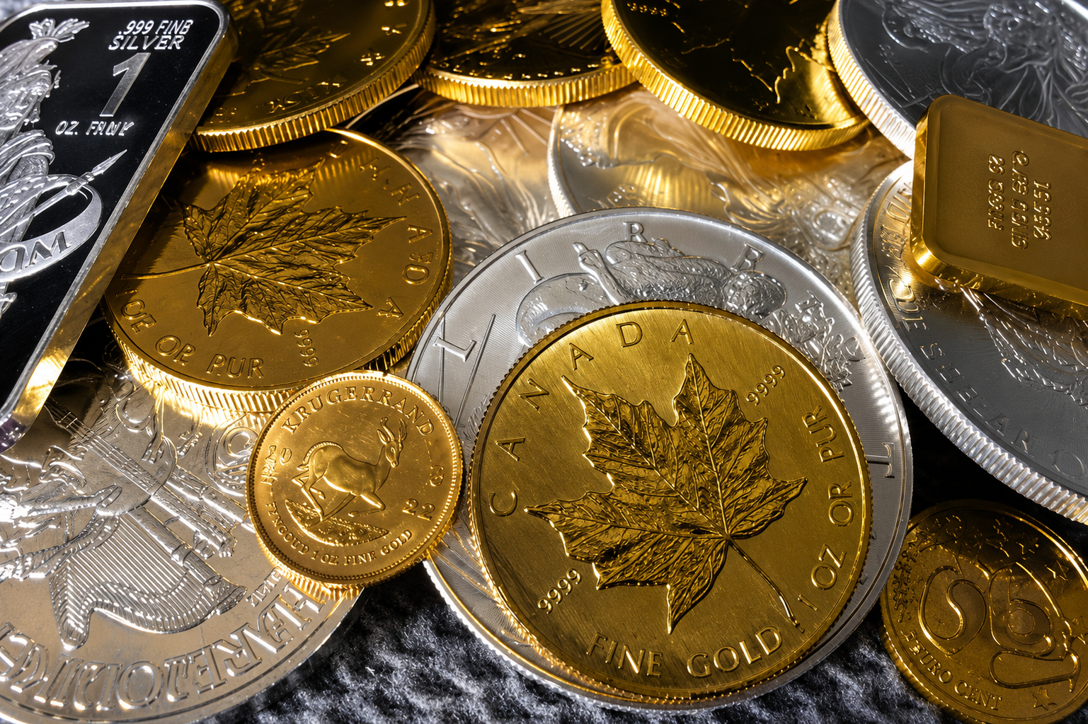 Gold and silver coins stacked and scattered on a reflective surface with a maple leaf design