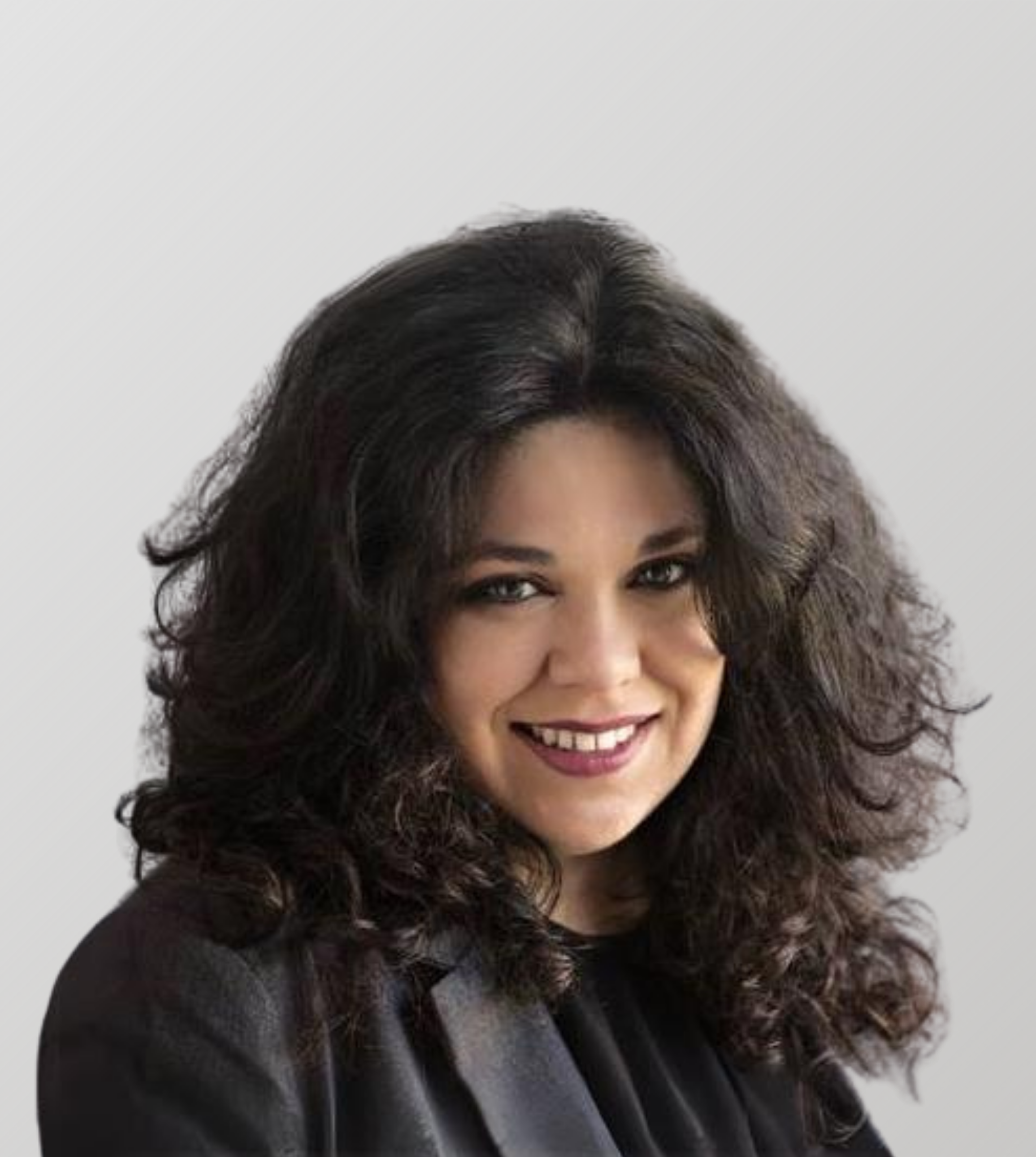 Woman with dark, curly hair smiles, wearing a black blazer.