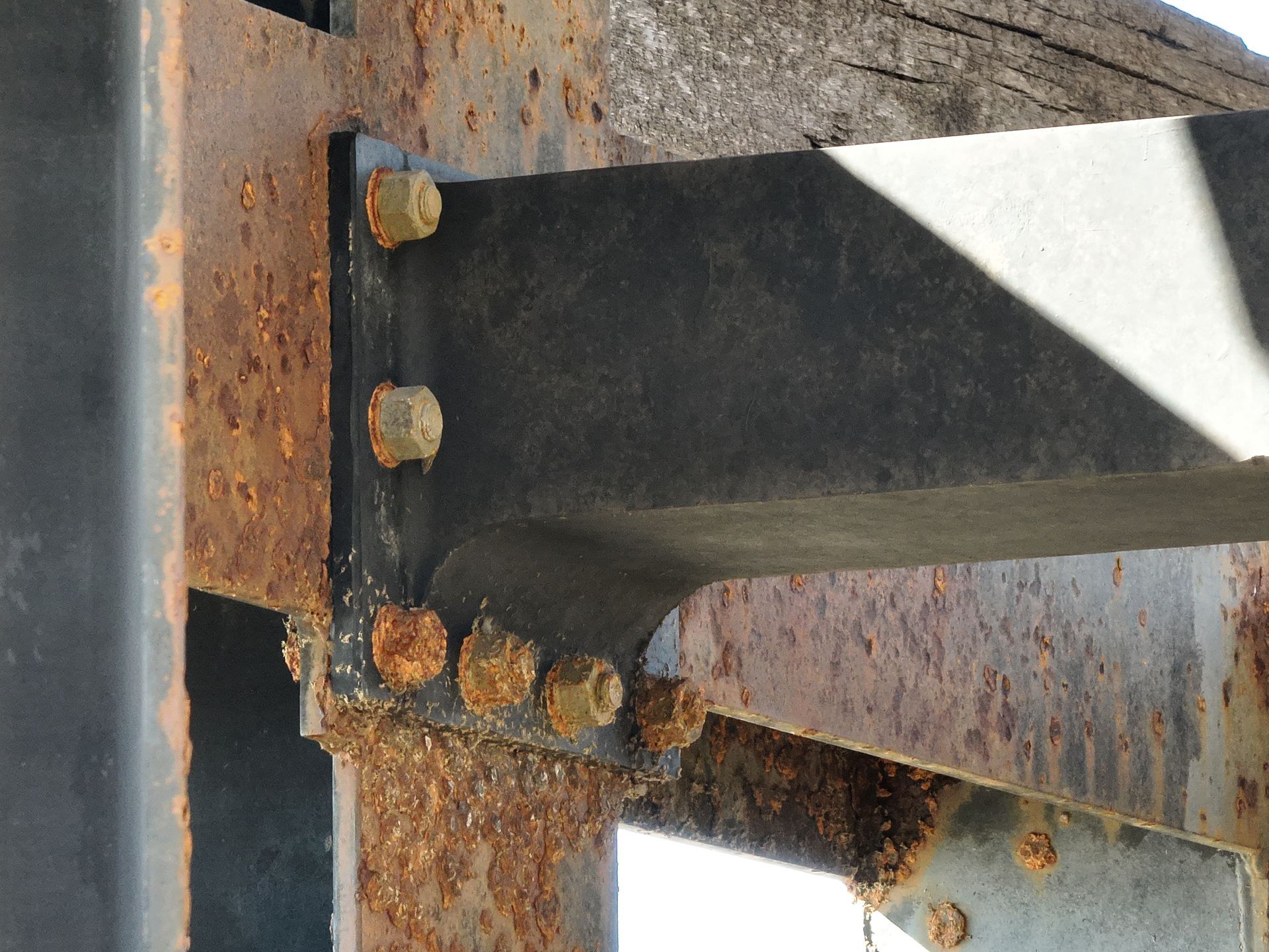 Rusty steel beam joint with bolts on a weathered metal structure