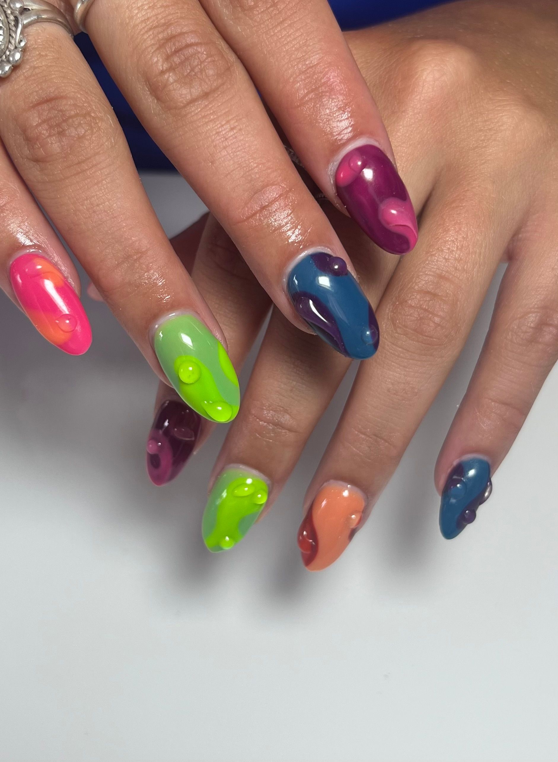 A close up of a woman 's nails with neon colors