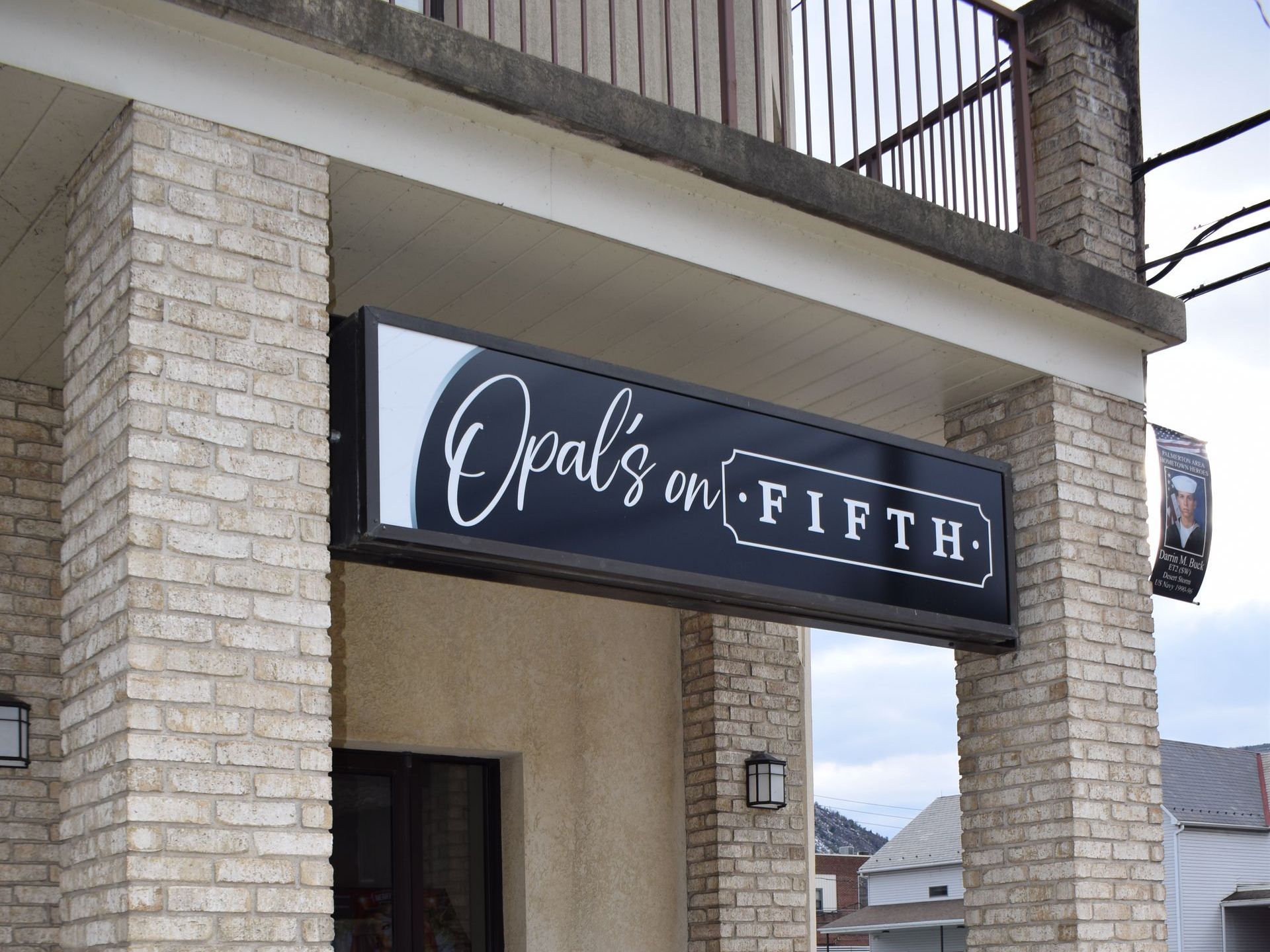 A brick building with a sign that says opal 's on fifth