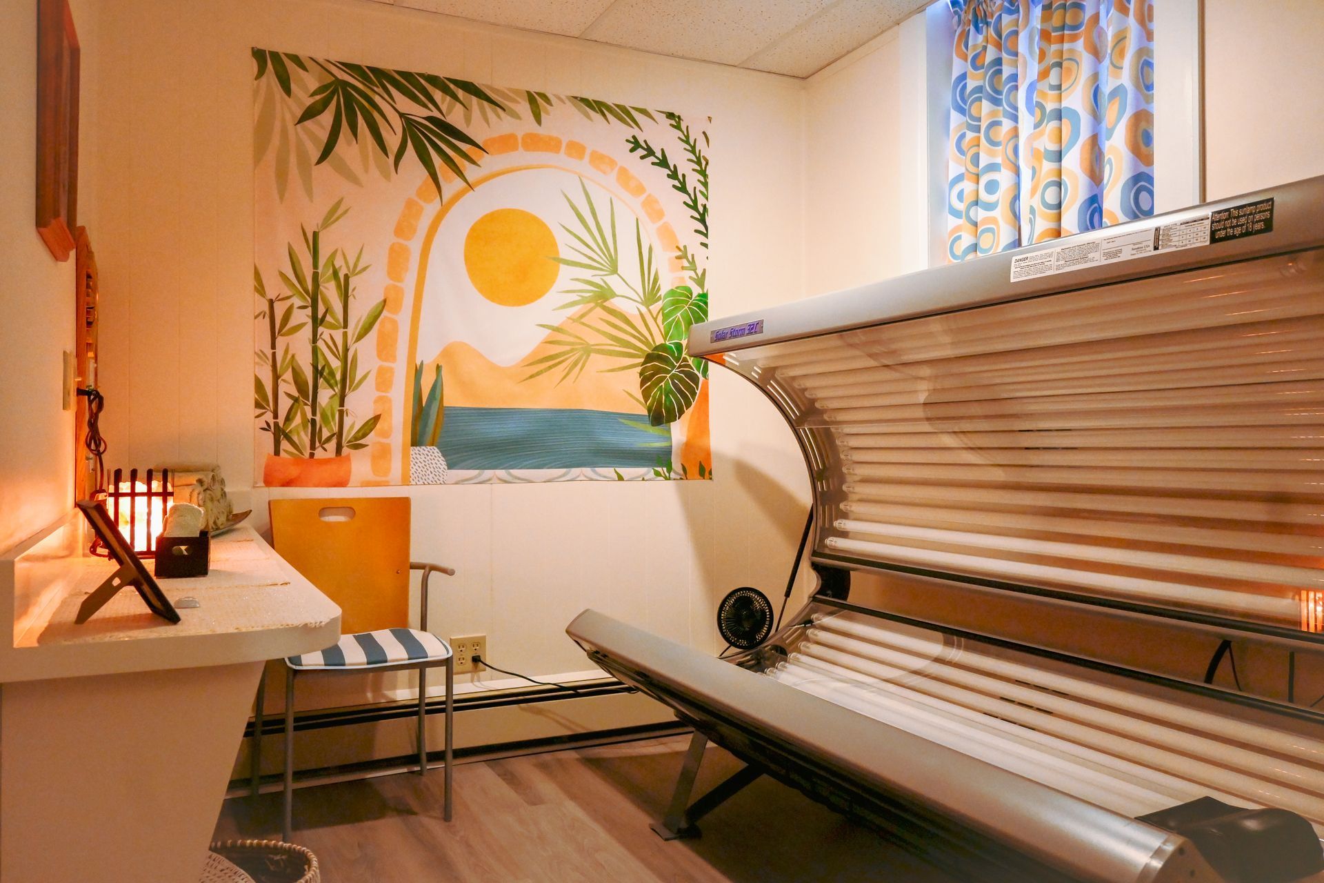 A room with a tanning bed and a painting on the wall.