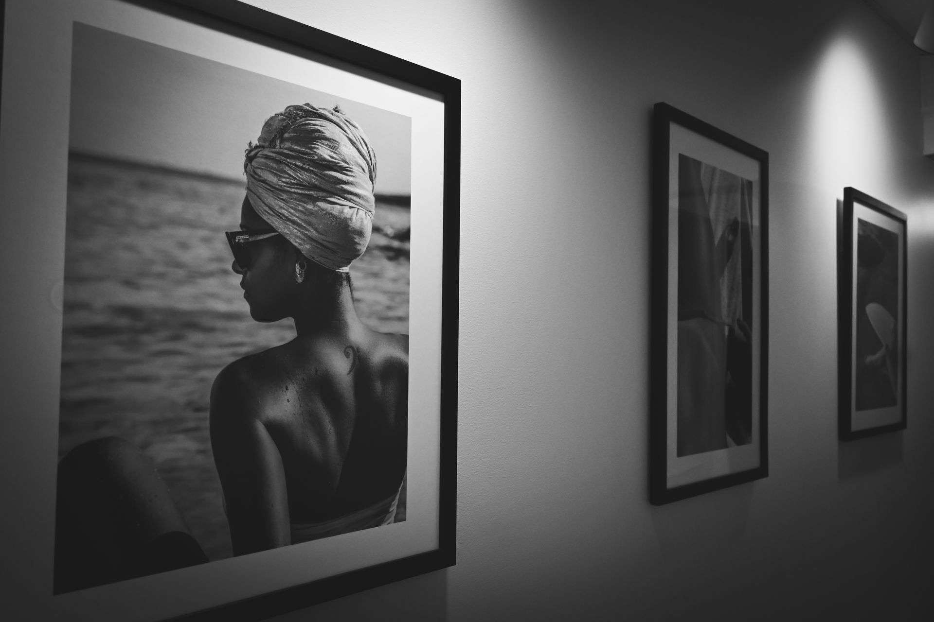 A black and white photo of a woman wearing a turban is hanging on a wall.