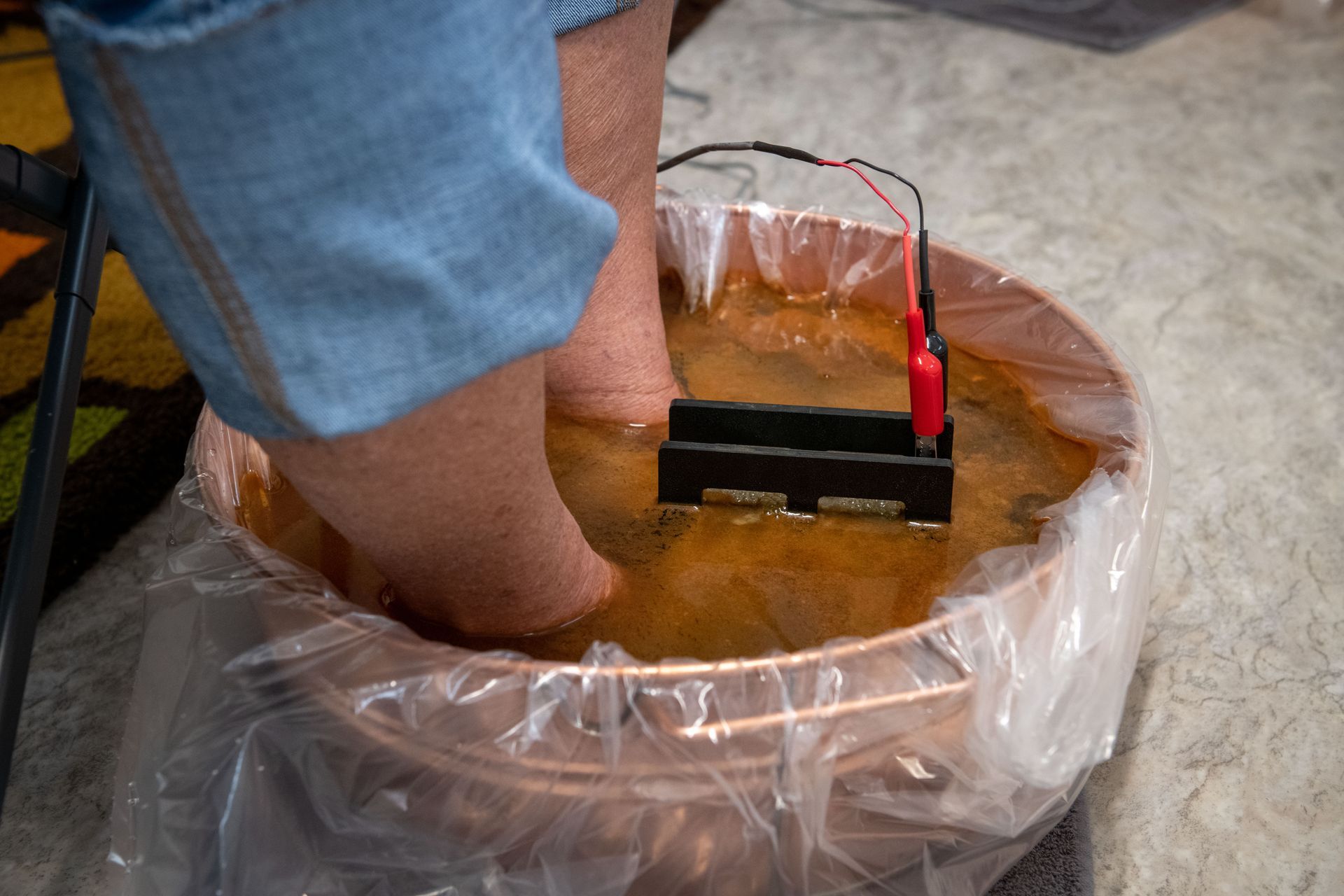 A person is standing in a bowl of water with their feet in it.