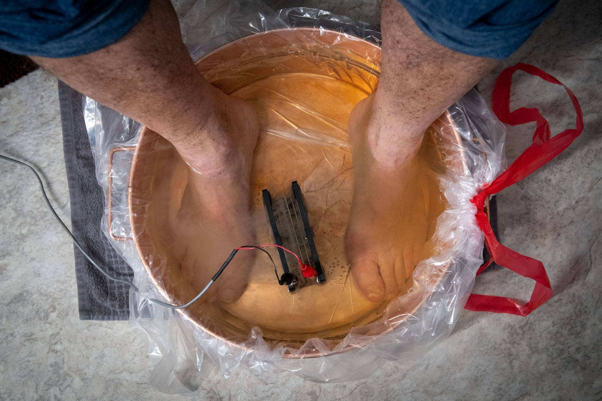A person is washing their feet in a bowl of water.