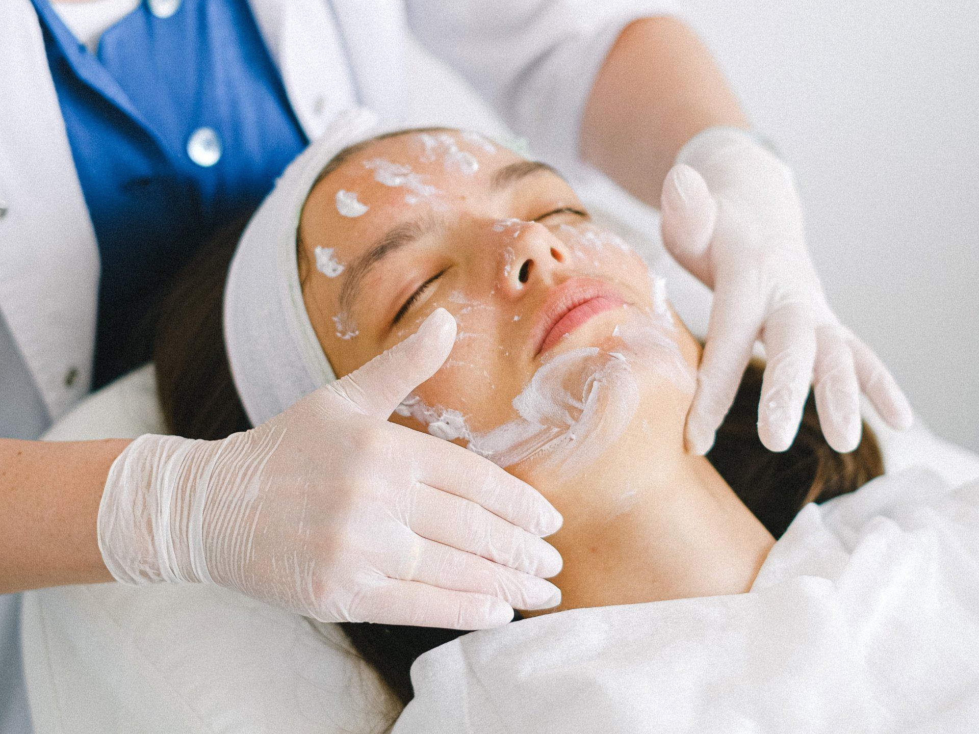 A woman is getting a facial treatment at a beauty salon.
