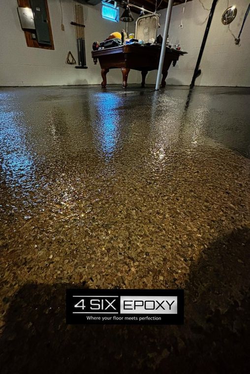 Polished speckled epoxy floor in a room, reflecting blue light, with a 4 Six Epoxy logo at the bottom.
