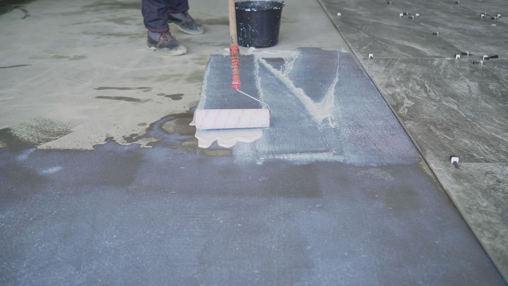 Worker troweling wet concrete near a curb, smoothing a repaired sidewalk patch