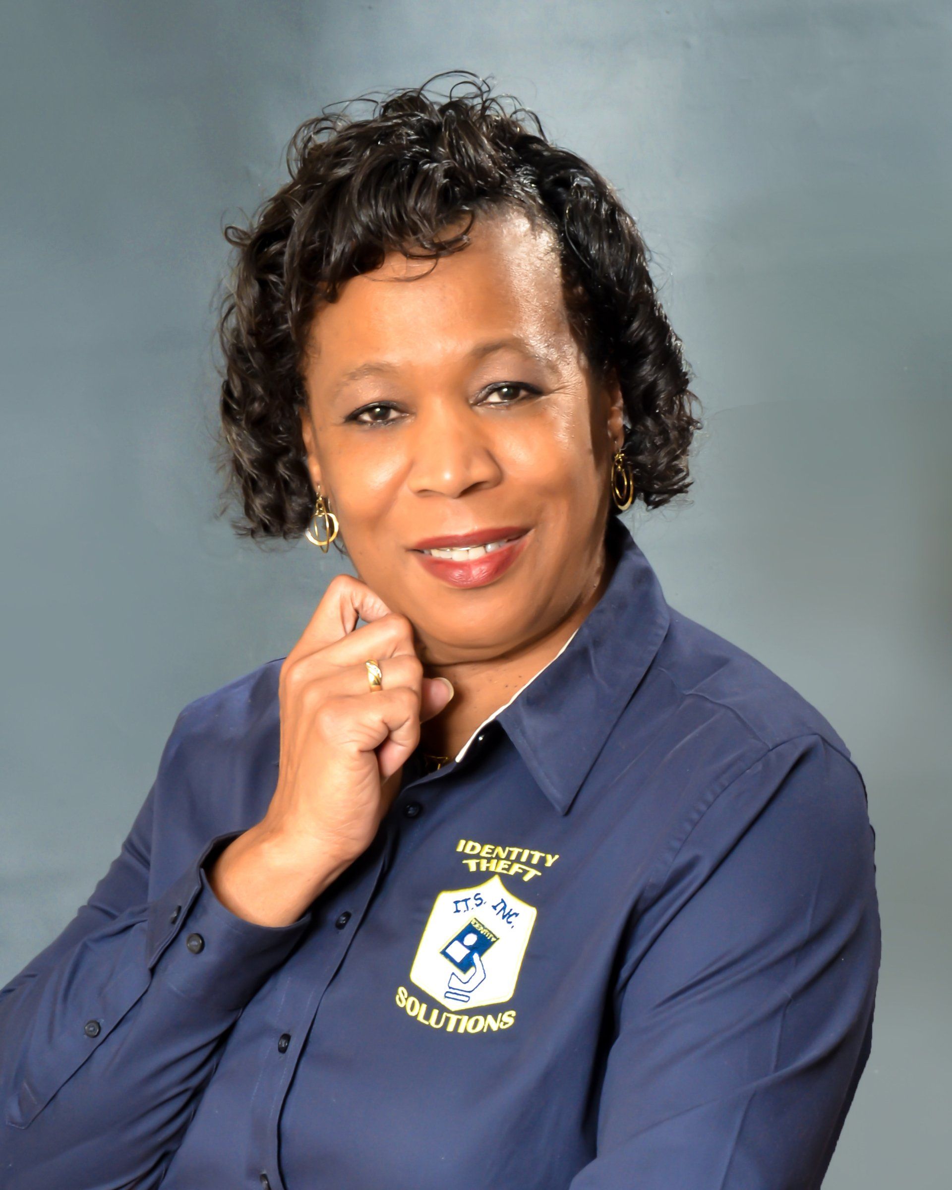 A woman wearing a blue shirt with a crest on it