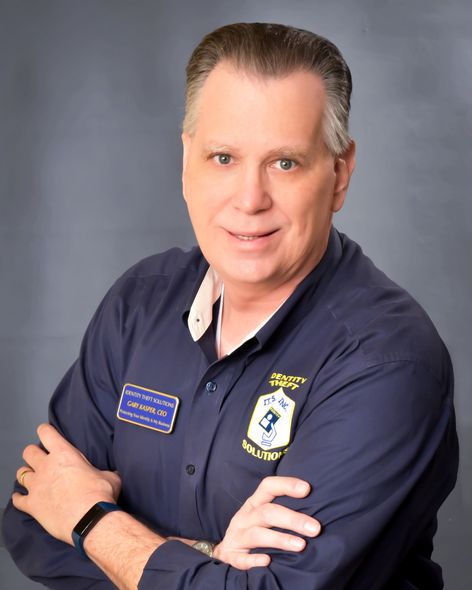A man with his arms crossed wearing a blue shirt with a patch on it