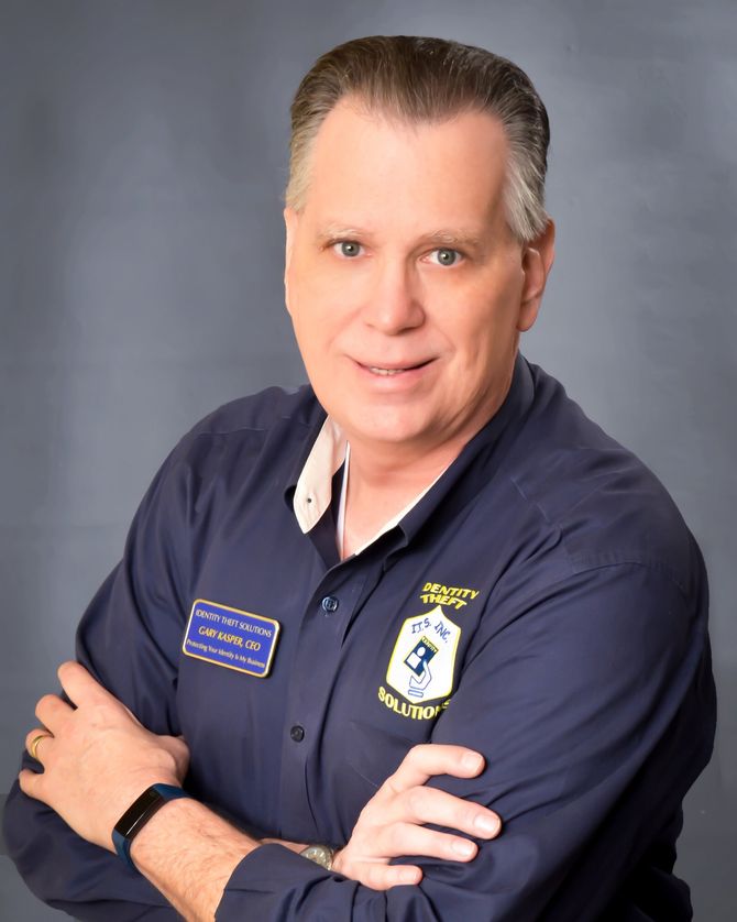 A man with his arms crossed wearing a blue shirt with a patch on it