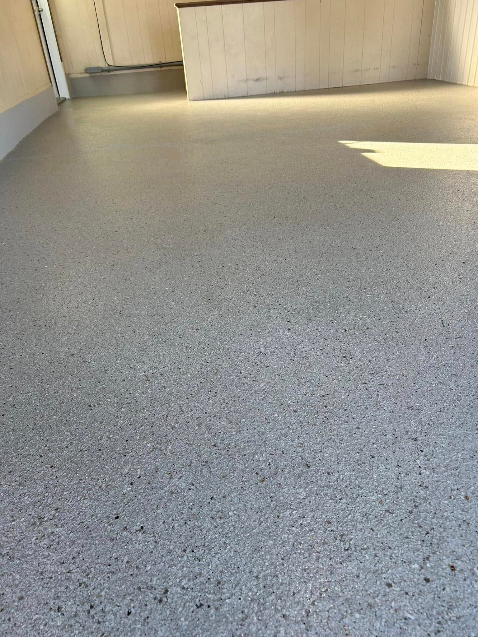Sol tacheté et vide dans un couloir, avec du soleil sur le mur de droite.
