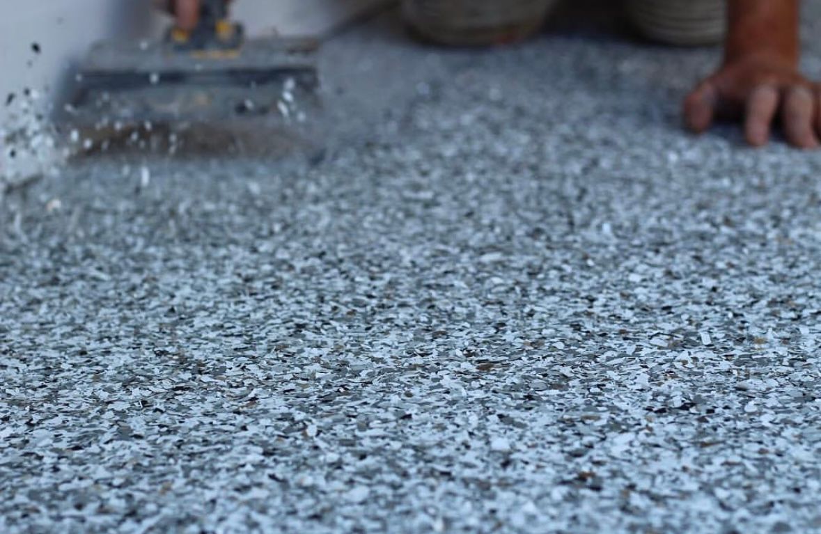 Châssis de robot noir avec câblage apparent et chenilles de char sur un tapis rouge, entouré d'autres robots.