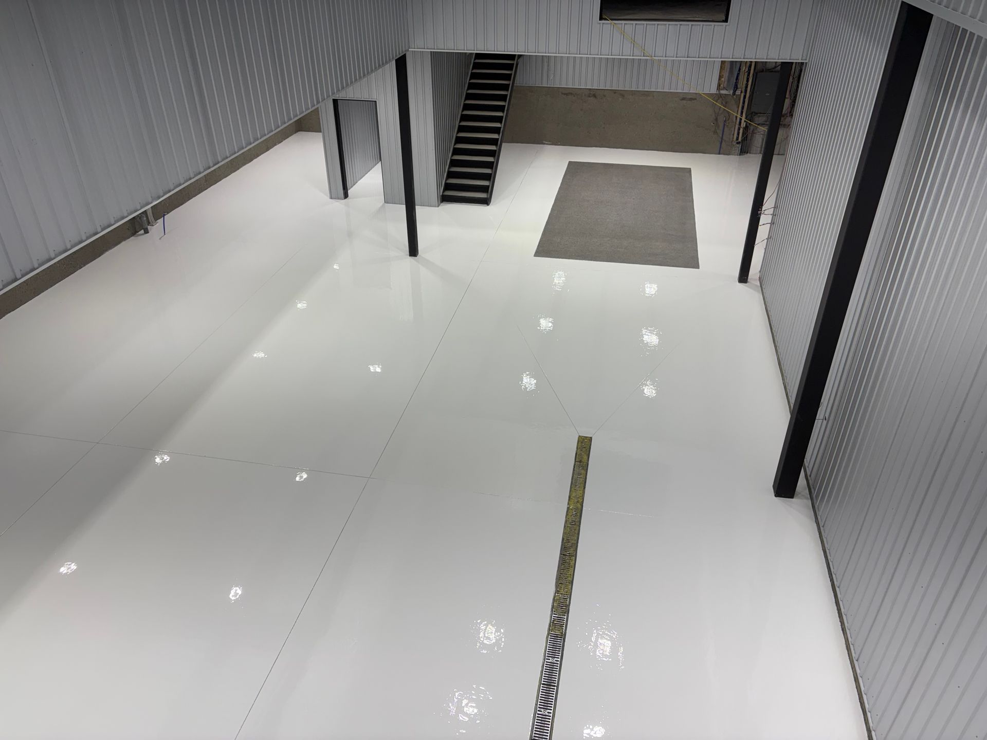 Allée d'entrepôt vide avec des rayonnages de stockage en métal rouge et un sol en béton poli