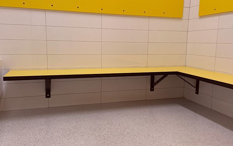 Banc de comptoir vide jaune et noir le long d'un mur carrelé dans une pièce