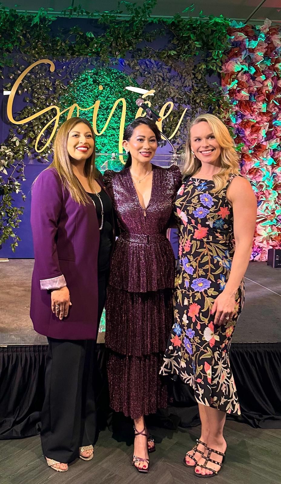 Three women are posing for a picture together at a party.