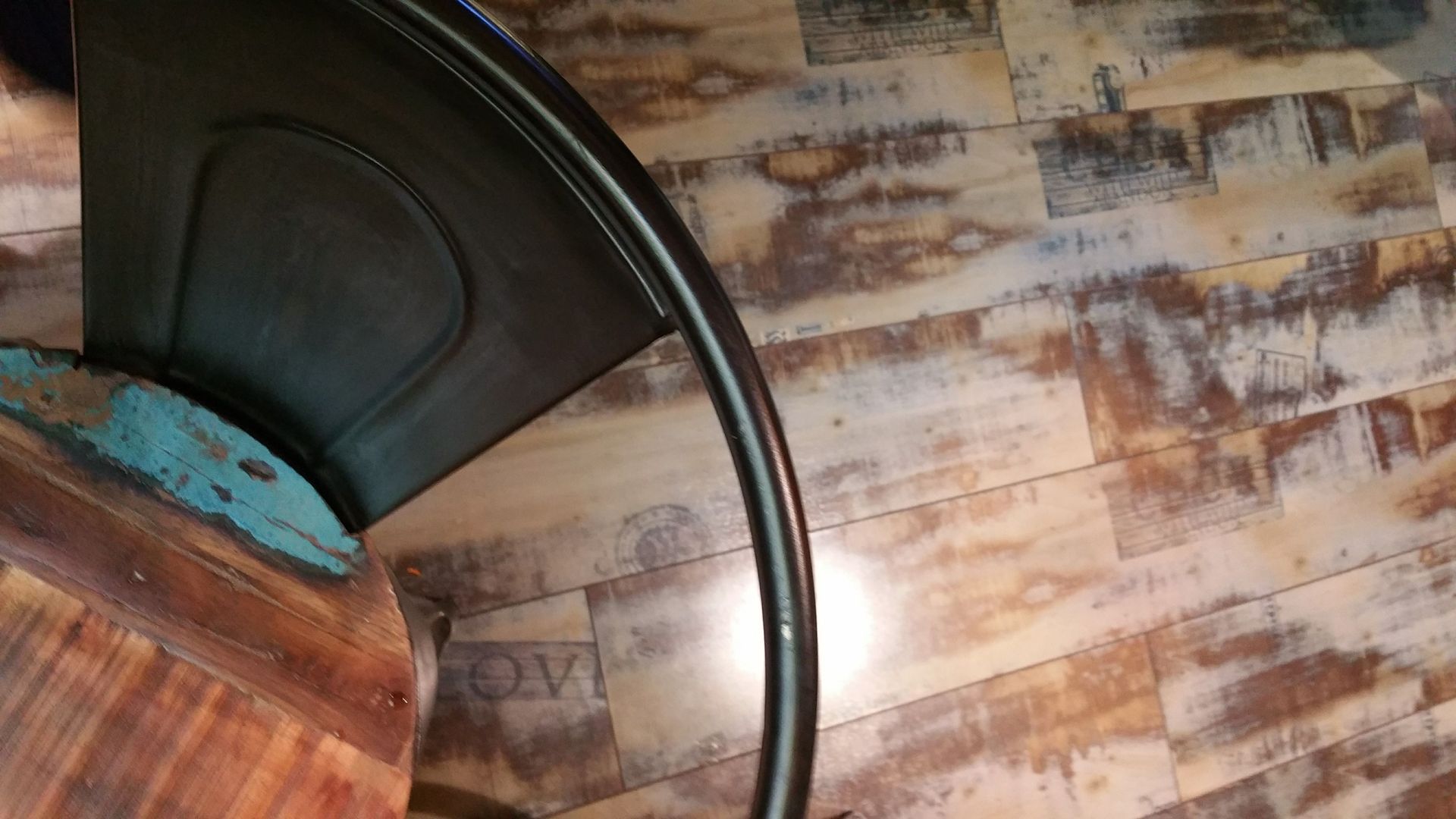 Close-up of a wooden chair with a black metal frame on a patterned rug