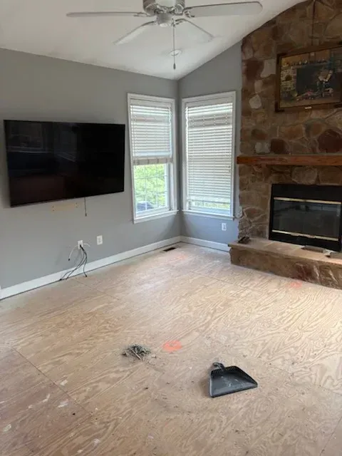Modern living room with brown sofas, wood floors, a coffee table, and a large window view