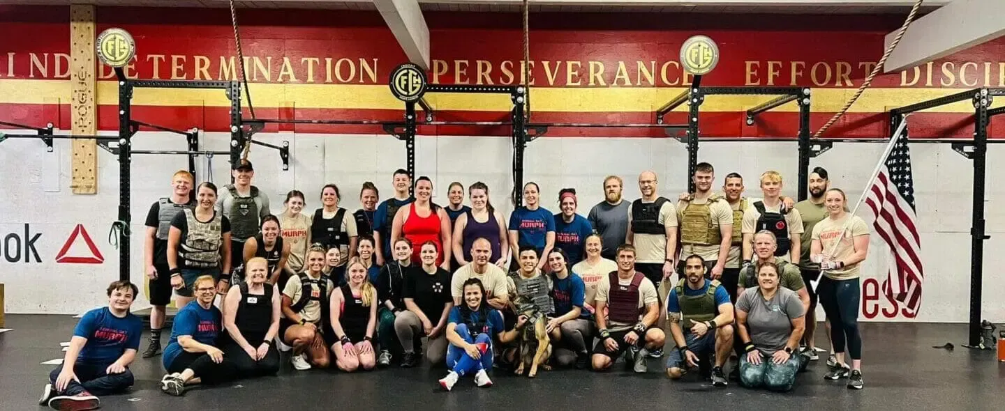 A large group of people are posing for a picture in a gym.