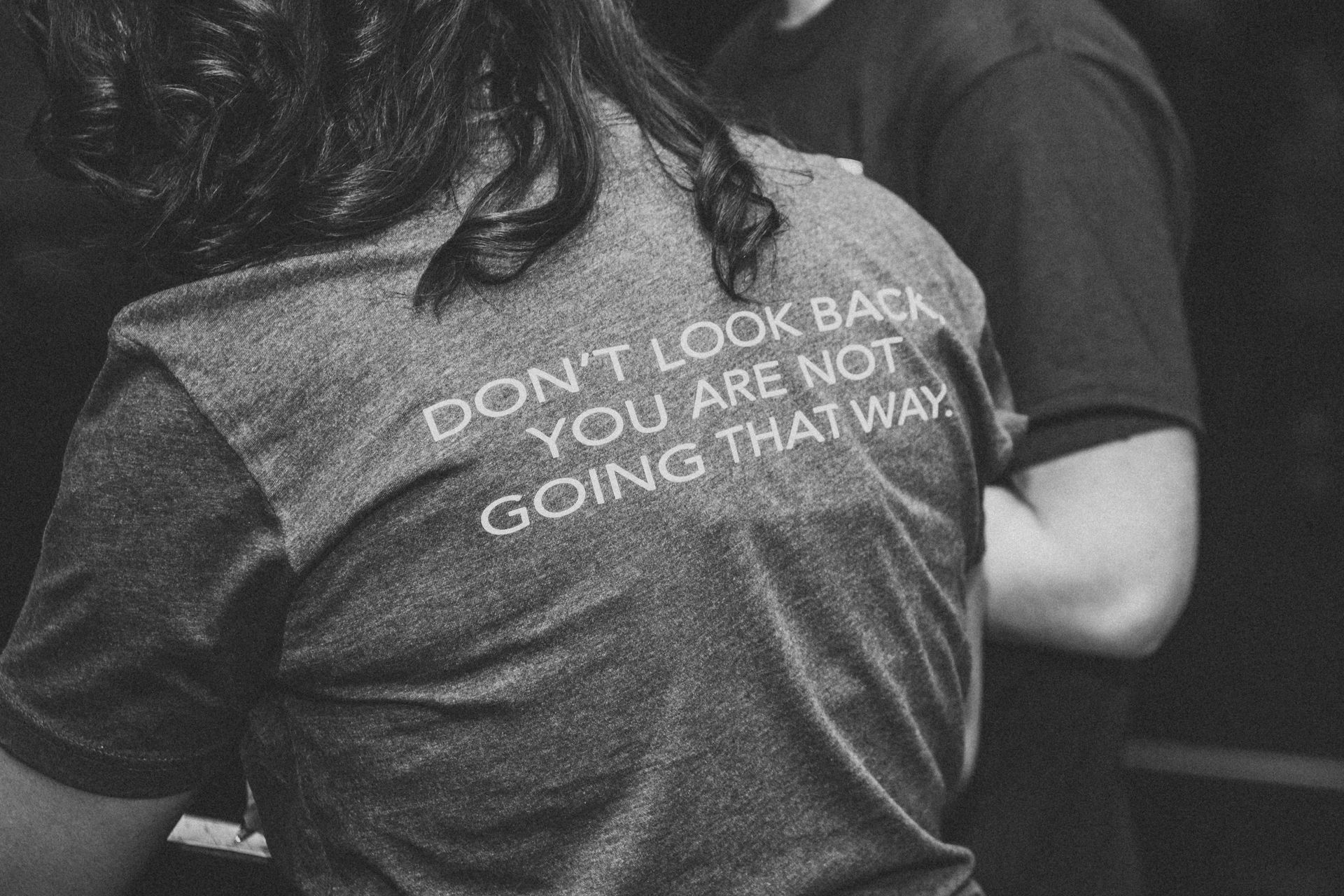 A woman is wearing a t-shirt that says do n't look back you are not going that way.