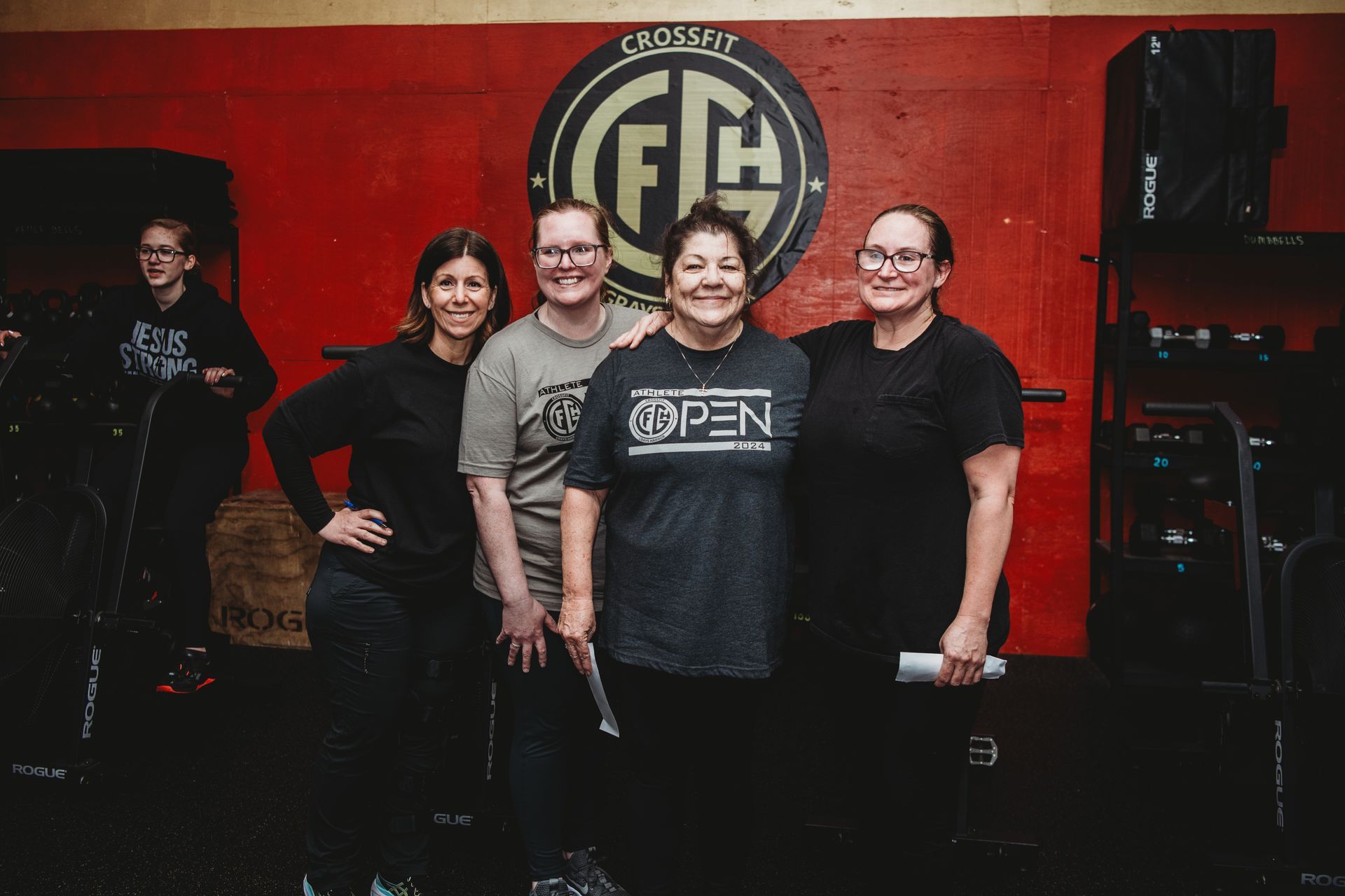 A group of people are posing for a picture in front of a red wall.