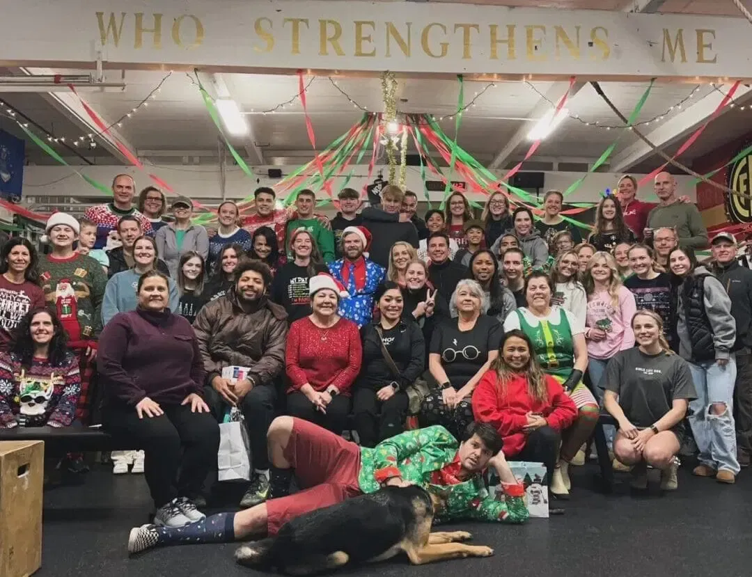 A large group of people are posing for a picture in a gym.