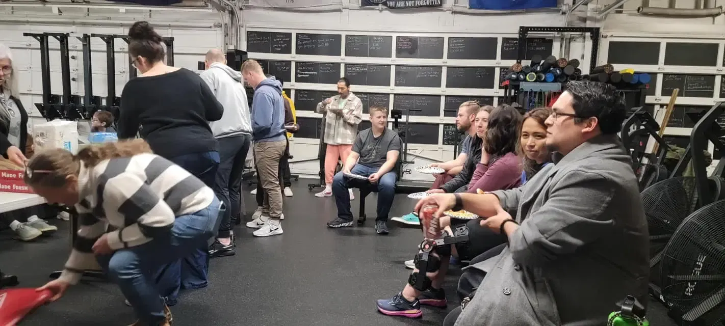 A group of people are sitting in a gym.