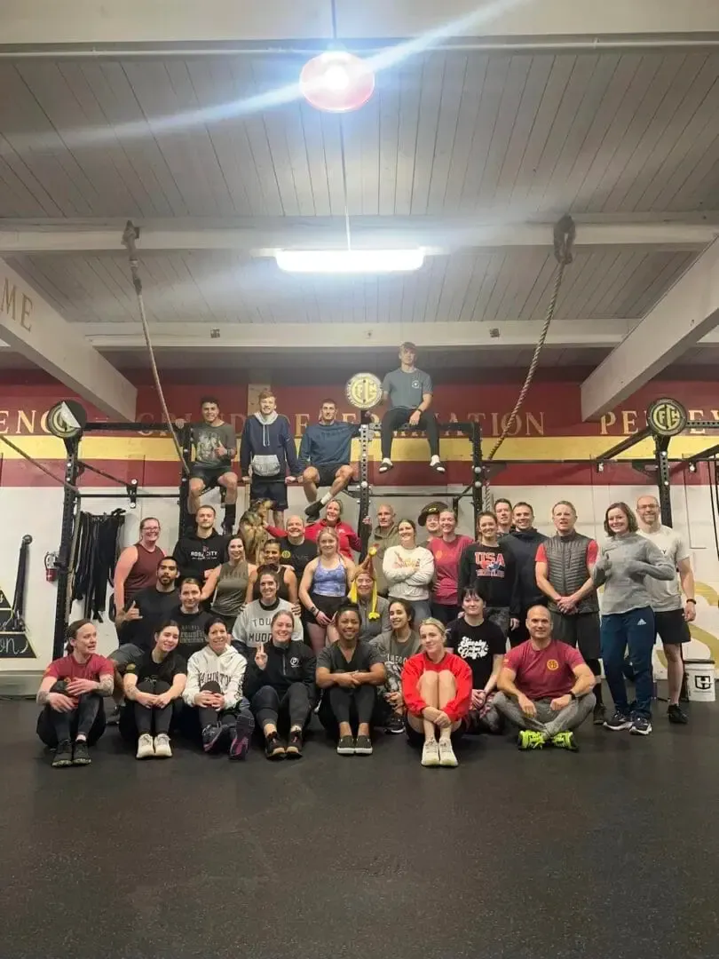 A group of people are posing for a picture in a gym.