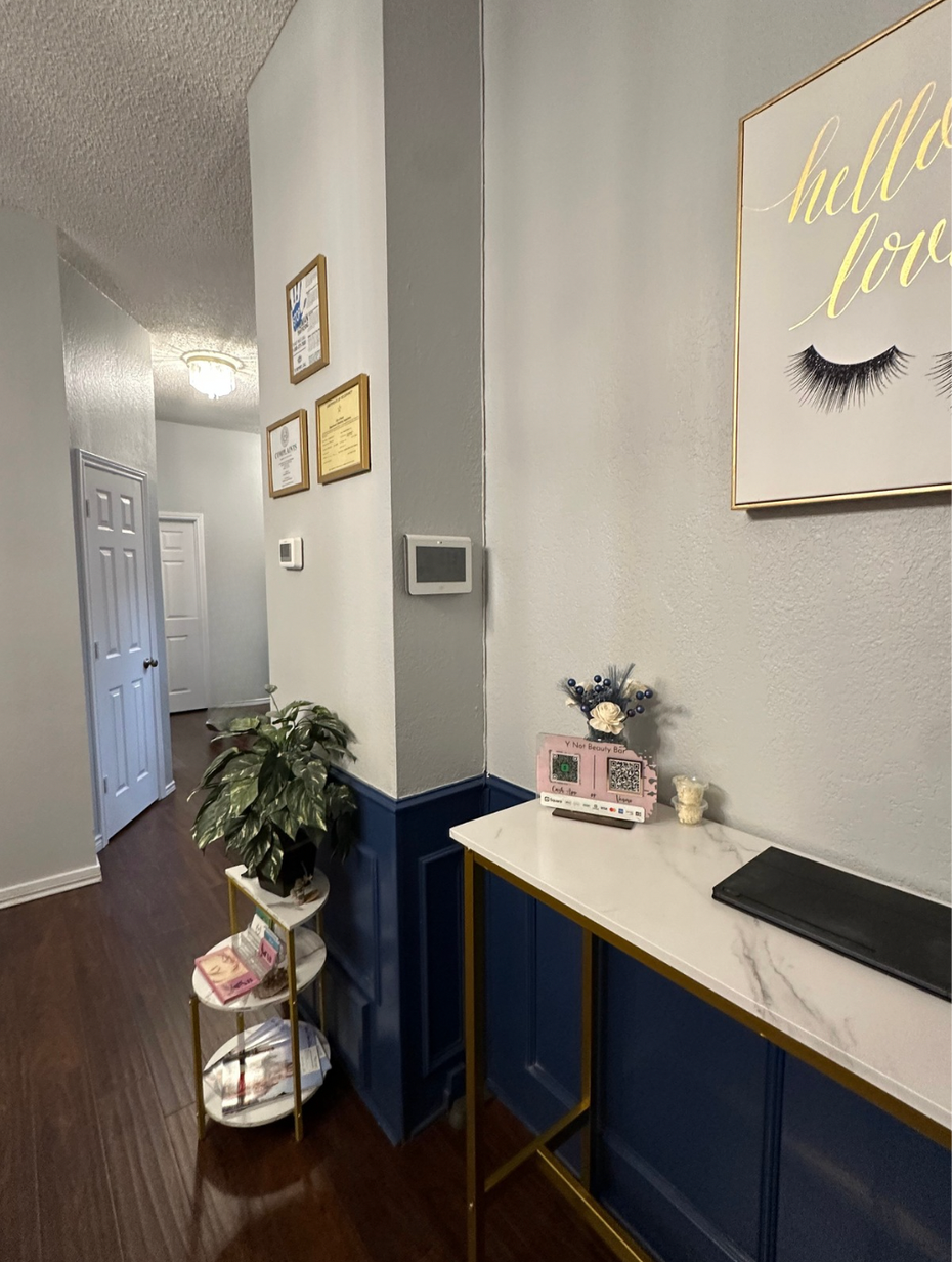 A hallway with a table and a picture on the wall.