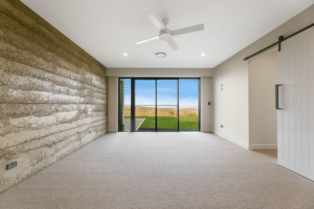 An Empty Room With a Ceiling Fan and Sliding Glass Doors — Windamere Homes in Highfields, QLD