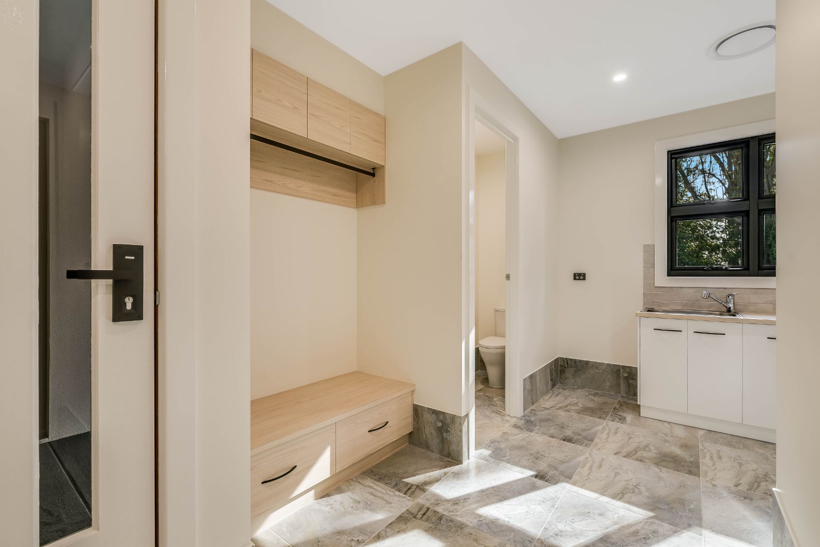 A Laundry Room With a Sink, Toilet and Window — Windamere Homes in Highfields, QLD