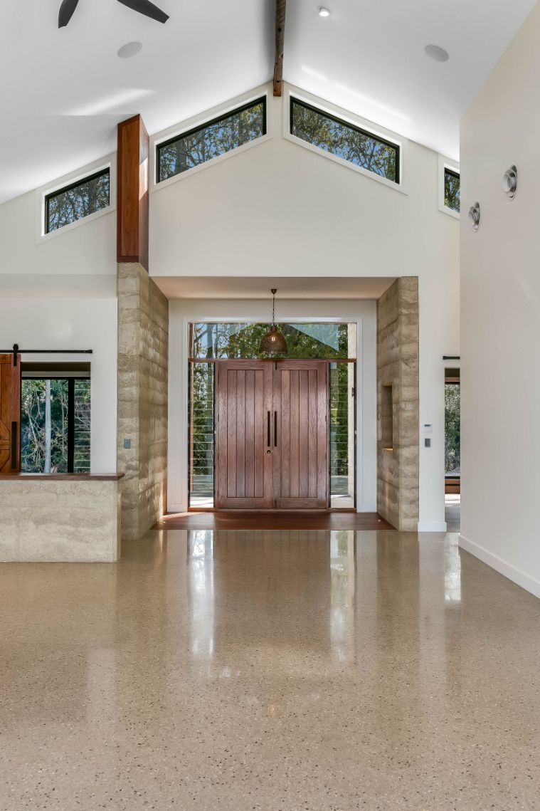 A Large Empty Room With a Ceiling Fan and a Copper Refrigerator — Windamere Homes in Highfields, QLD