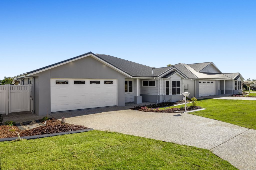 A Large White House With Two Garage Doors and a Driveway — Windamere Homes in Highfields, QLD