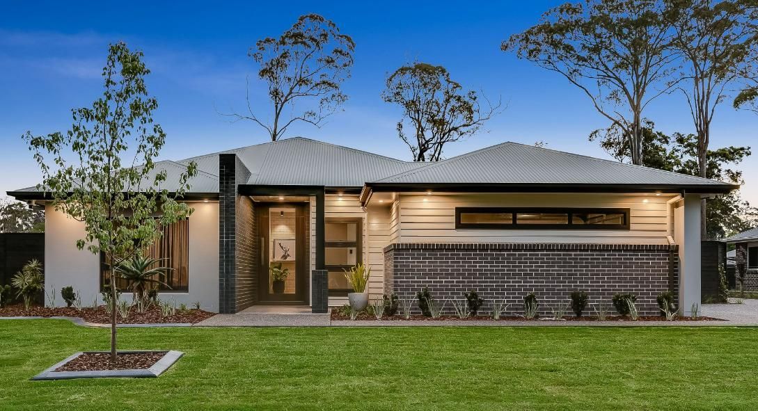 A Modern House With a White Roof is Sitting on Top of a Lush Green Lawn — Windamere Homes in Highfields, QLD