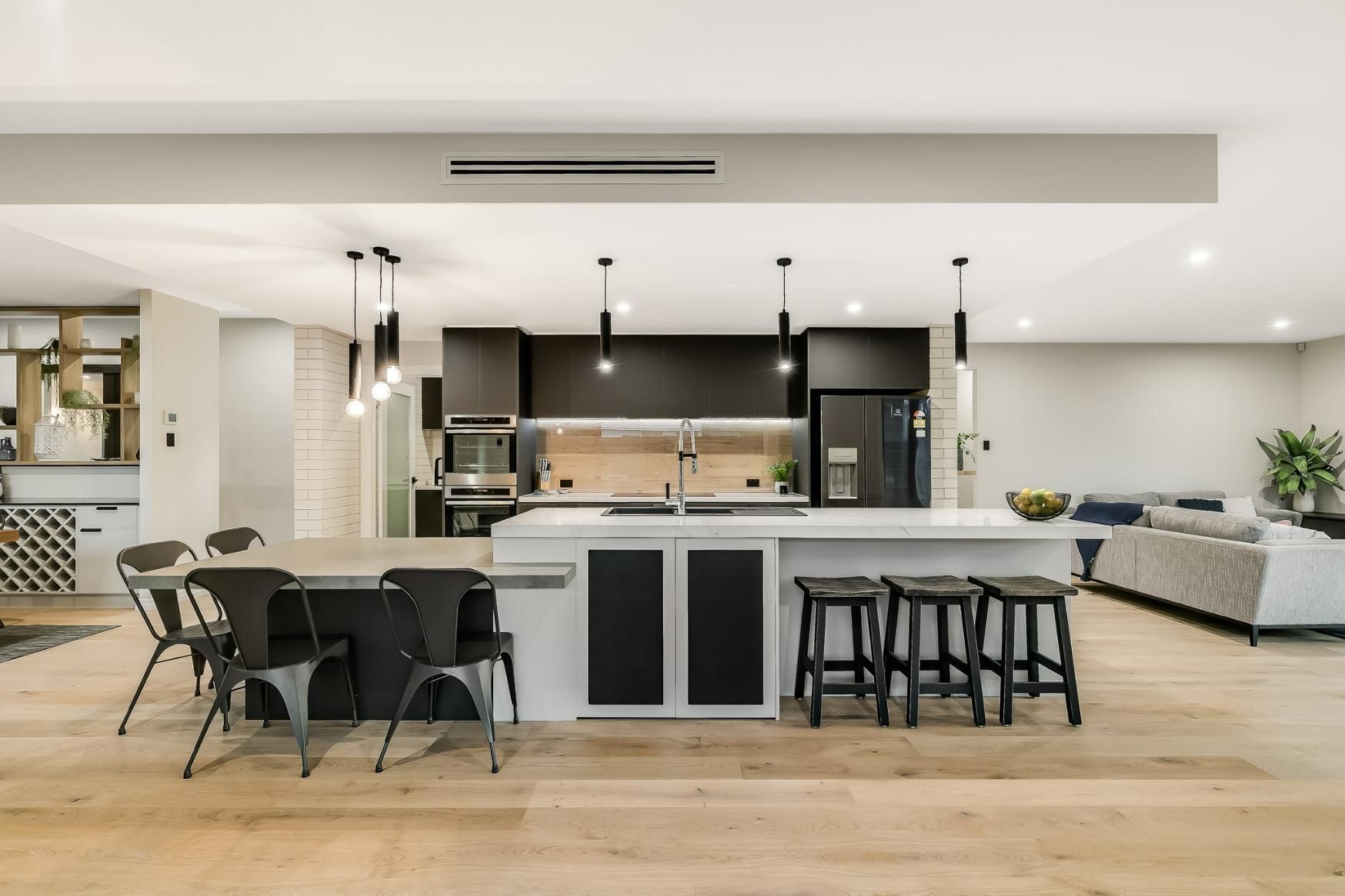 A Kitchen With a Large Island and a Table and Chairs — Windamere Homes in Highfields, QLD