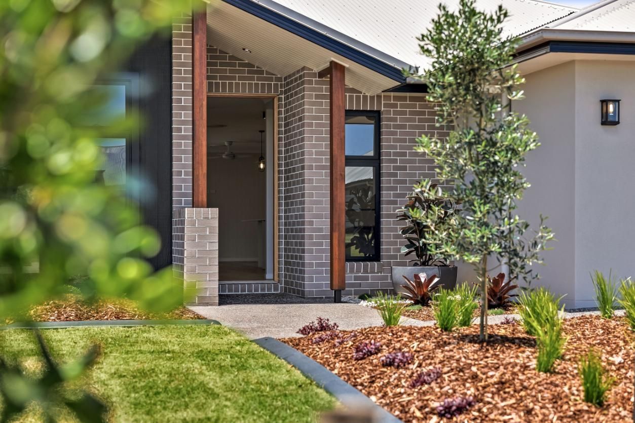 A House With a Porch and a Tree in Front of It — Windamere Homes in Highfields, QLD