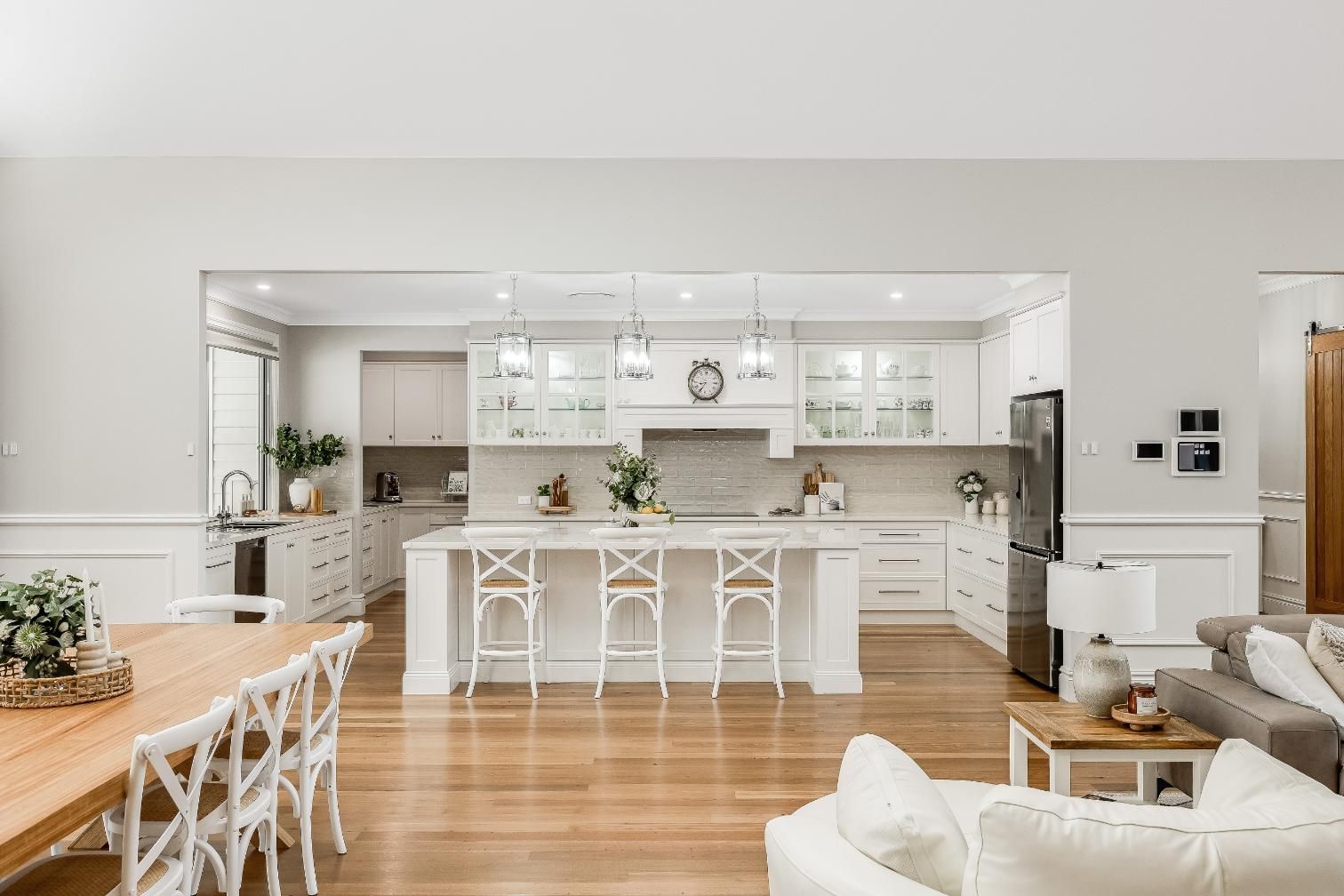 A Kitchen and Dining Room in a House With White Cabinets and Wooden Floors — Windamere Homes in Highfields, QLD