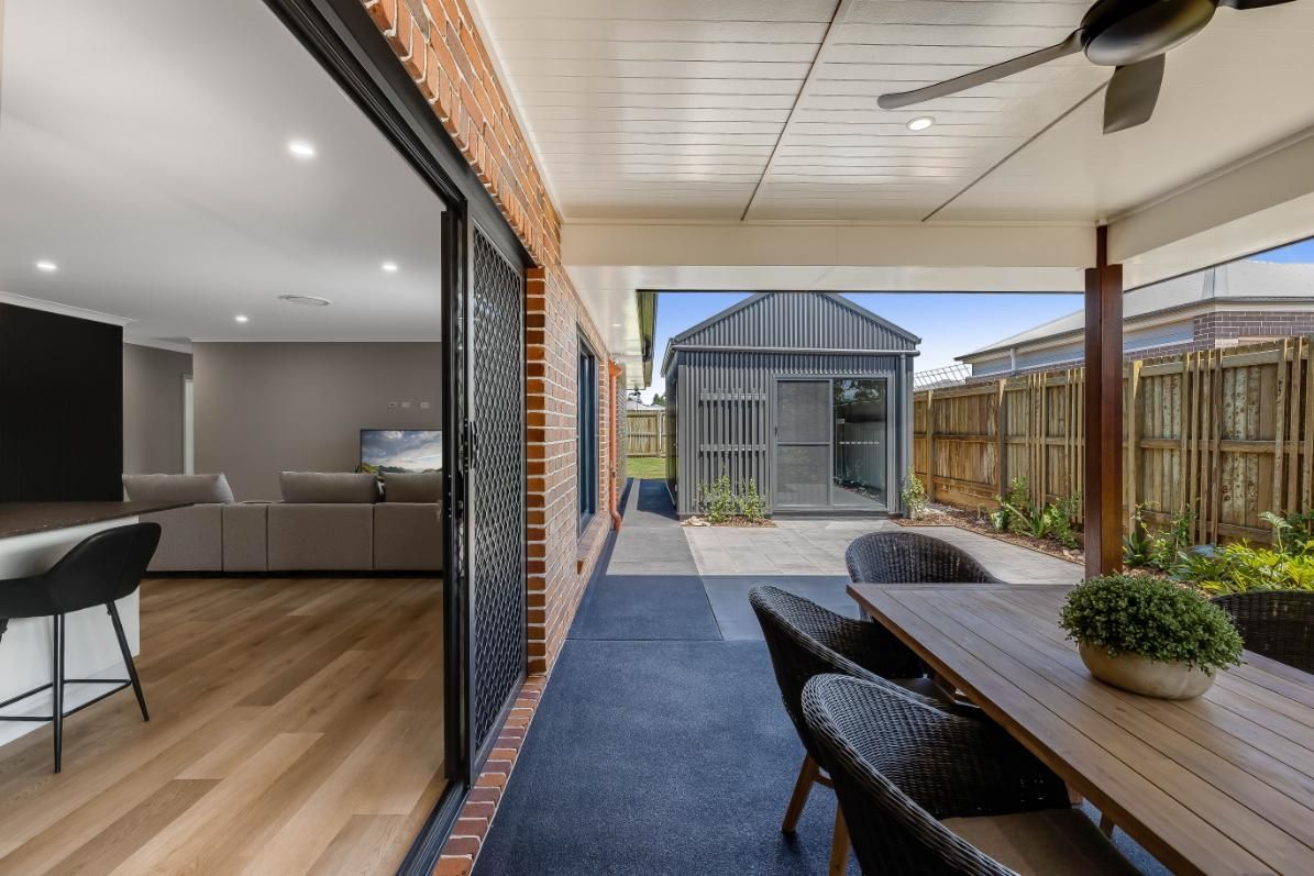 A Table, Chairs, and Ceiling Fan — Windamere Homes in Highfields, QLD