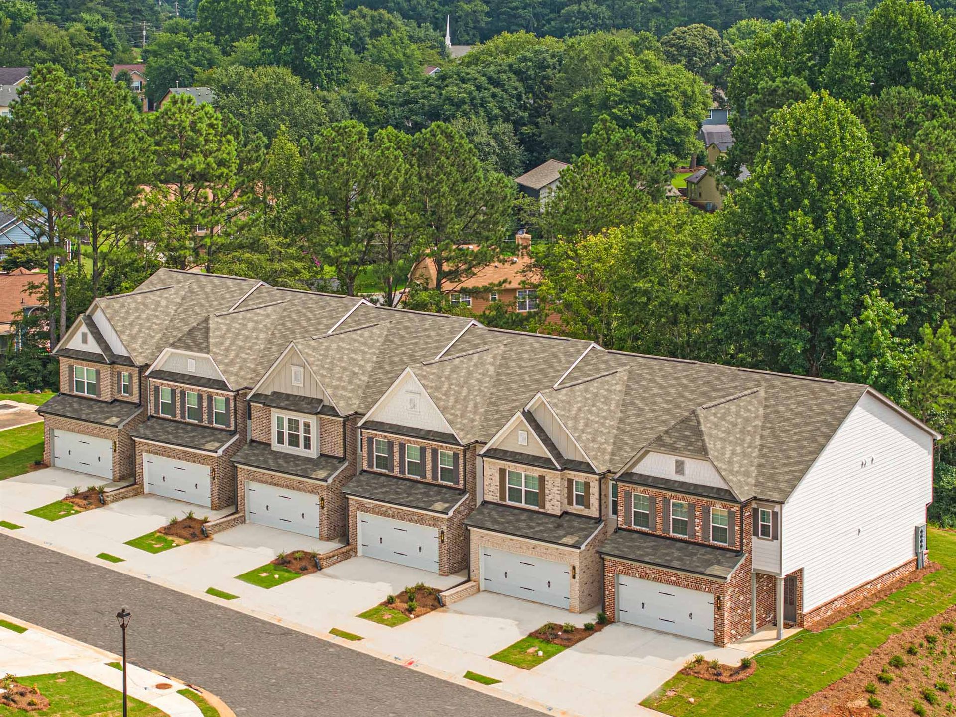 An aerial view of a row of houses with garages in a residential area at Collins Place.