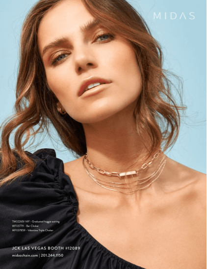 A woman is wearing a black top and a gold necklace