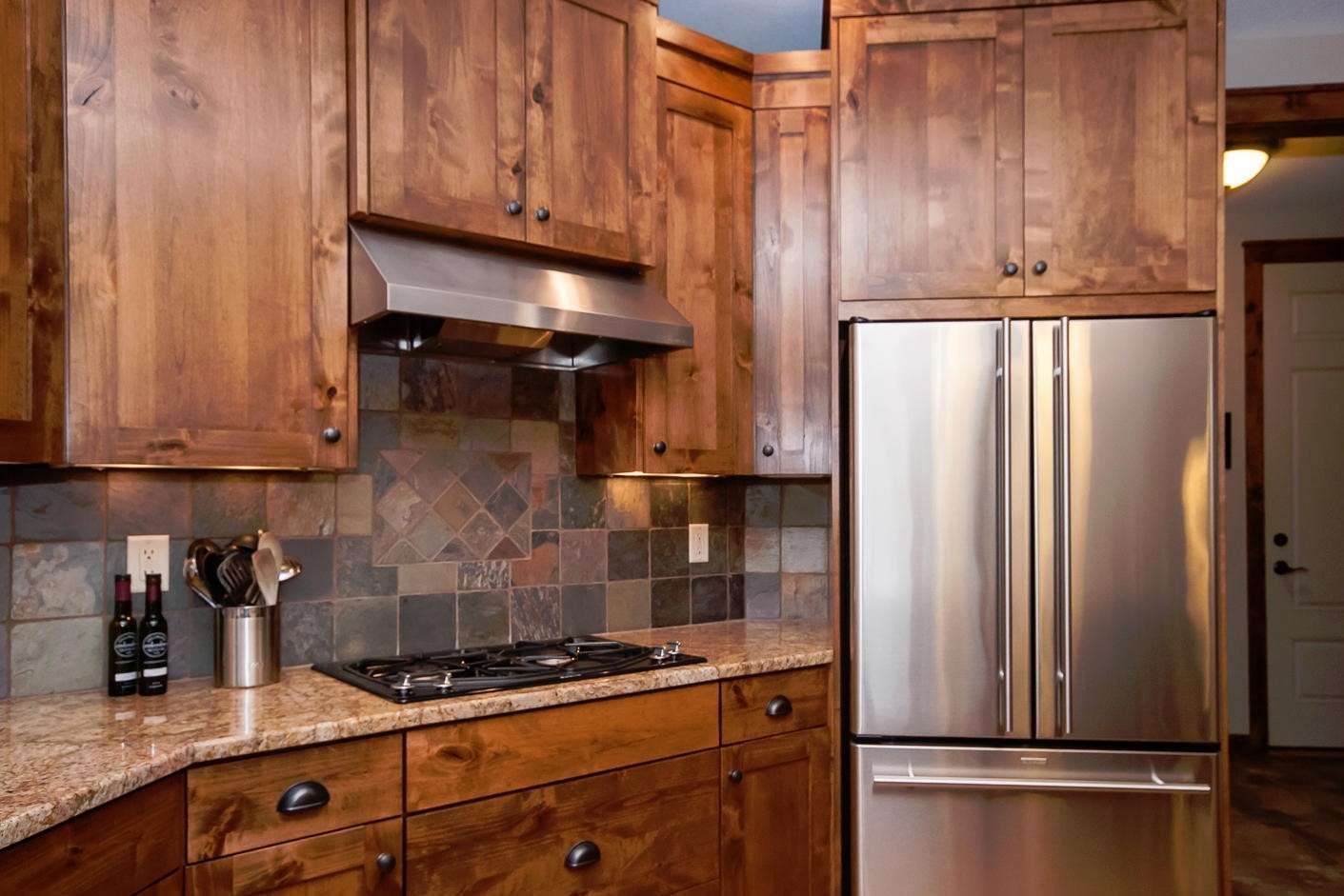 Kitchen with wooden cabinets, stainless steel appliances, and a tiled backsplash.